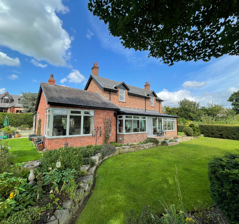 large family home in the countryside with light grey edged windows and matching entrance door