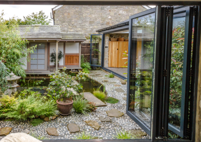 bi-fold doors opening onto a garden with a pond