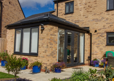 an orangery with large windows and patio doors