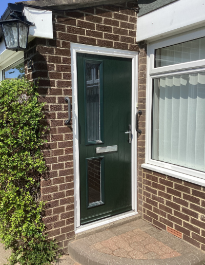 dark green entrance door with 2 small glass windows