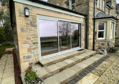 large traditional stone building with grey trim sliding doors