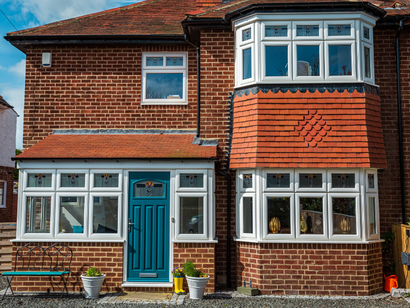 Front of red brick house with blue front door and white windows