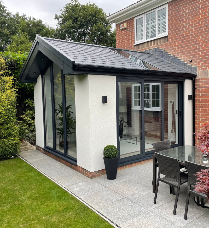 warm roof / sunroom featuring black roof and large windows