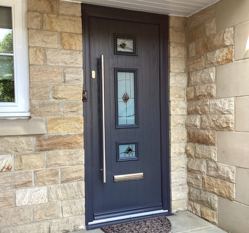 entrance door with large handle and 3 windows with details