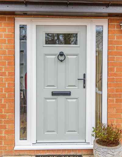 light grey entrance door with black handle, letterbox & knocker