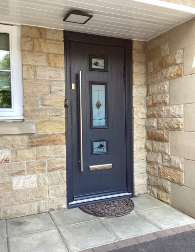 entrance door with 3 small stained glass windows and a modern long handle