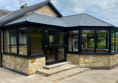 conservatory with black trimming and stone brickwork