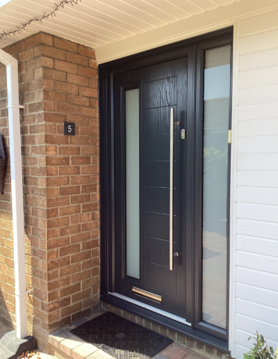 modern entrance door with large handle and 2 long frosted glass windows