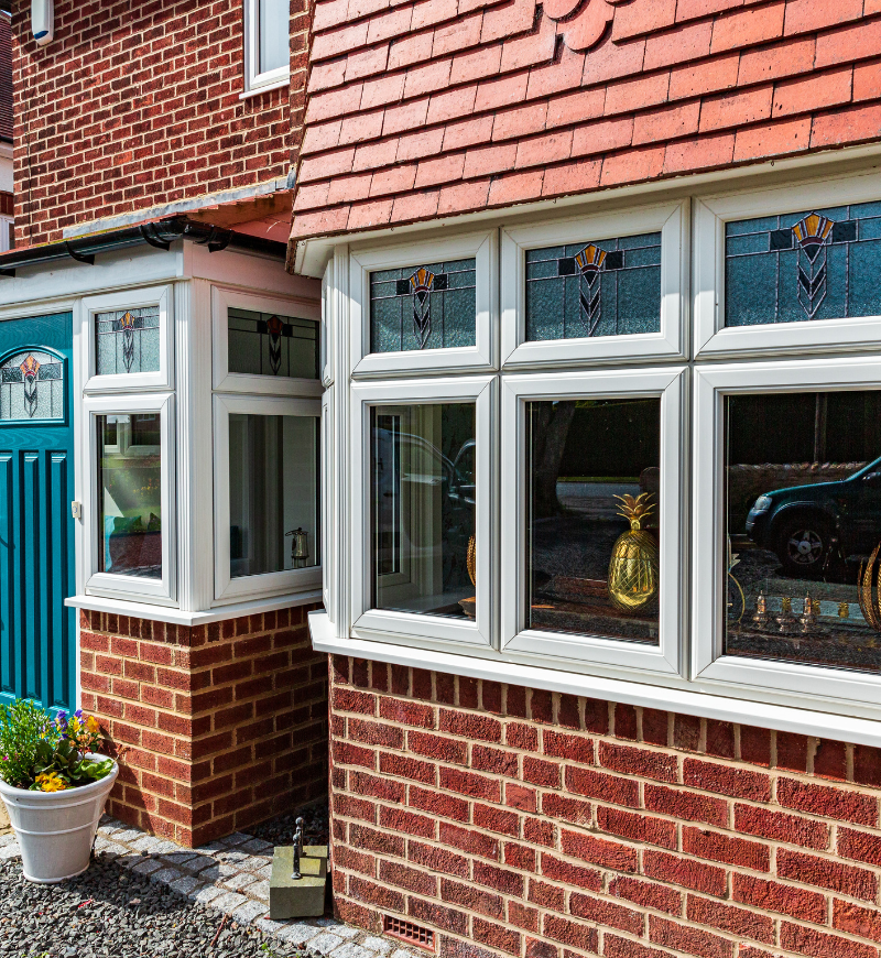 teal entrance door and large bay window