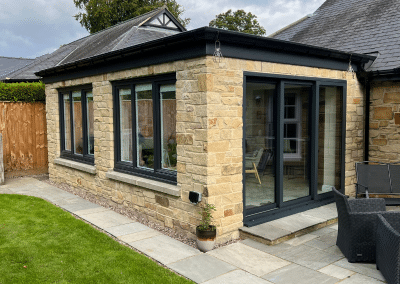 A square sandstone orangery with black details