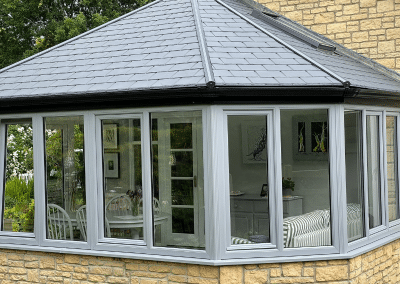 A grey and sandstone conservatory from the outside