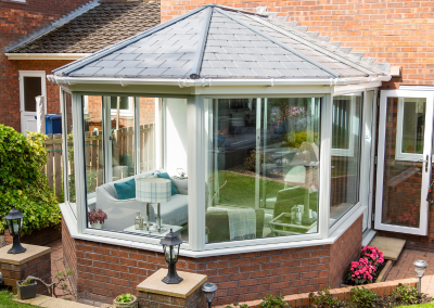 A glass and orange brick conservatory with slate roof