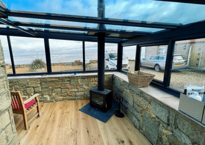 A glass conservatory from the inside with a log burner